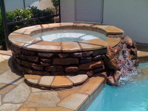 custom-natural-stone-hot-tub-runs-into-pool